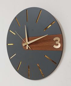 a wooden clock with gold numbers on it