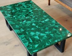 a green table sitting on top of a hard wood floor next to a couch and chair