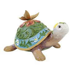 a ceramic turtle figurine with flowers on its shell