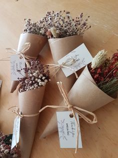 several flowers are wrapped in brown paper and tied with twine on a table top