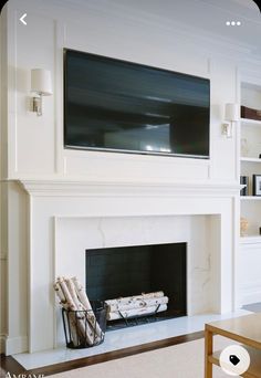 a living room with a large flat screen tv mounted on the wall above a fireplace