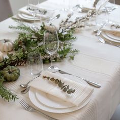 the table is set with white plates and silverware