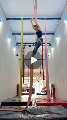 a woman is performing aerial acrobatic tricks on a trampoline course