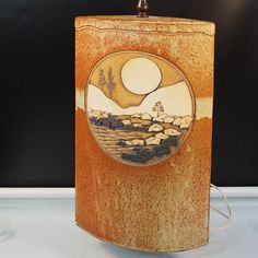 a wooden box with a painting on the front and side of it sitting on top of a table