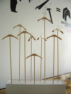 a group of wooden clothes pins sitting on top of a white shelf next to a wall