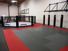 an empty gym with black and red mats