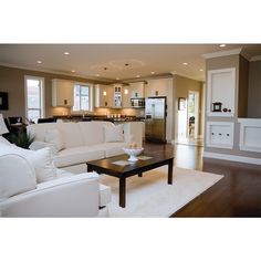 a living room filled with furniture and a flat screen tv on top of a hard wood floor