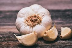 an onion and two pieces of garlic on a wooden table stock images, food photography