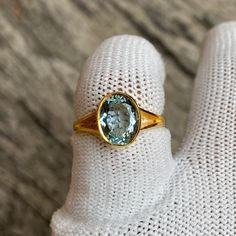 Dive into the ethereal beauty of the ocean with our stunning Aquamarine Ring. This exquisite piece is the embodiment of elegance and sophistication, featuring a 9x7 mm oval cut, 2.76 Carat Aquamarine gemstone set in lustrous 14K Gold. The aquamarine's enchanting sea-blue color, coupled with the timeless elegance of gold, creates a piece that is not just a ring, but a work of art. Born from the heart of the earth, each Aquamarine stone is unique, making your ring a one-of-a-kind treasure. Crafted Luxury 14k Gold Oval Sapphire Ring, Classic Oval Ring With High Luster, Classic Oval Rings With High Luster, Classic Oval High Luster Ring, Timeless Gold Oval Topaz Ring, Timeless Oval Gold Topaz Ring, Oval Yellow Gold Topaz Ring With Bezel Setting, Oval Yellow Gold Topaz Gemstone Ring, Timeless Oval Rings With High Luster