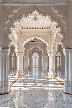 the interior of an ornate building with marble floors and arches in white, gold and grey colors