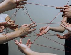 several people are holding their hands together and trying to connect with each other by stringing them