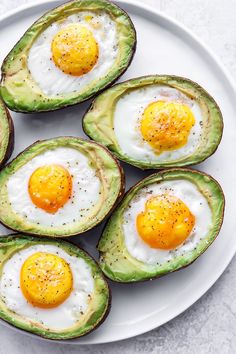 eggs in avocado halves on a white plate