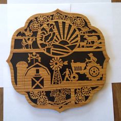 a wooden plaque with an image of farm animals and windmills on it, in the shape of a circle