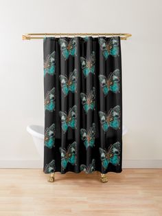 a blue butterfly shower curtain hanging on a bathroom wall next to a bathtub and wooden floor