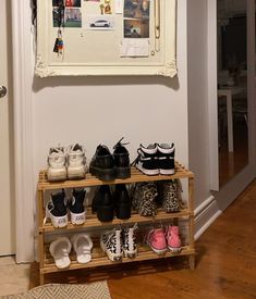 there are many pairs of shoes on the shelf in front of the mirror and door