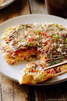 an omelet is on a white plate with chopsticks