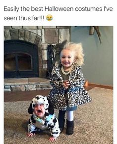 two children dressed up as dalmatian dogs in front of a fireplace