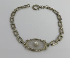 Estate art deco 1920's 14k white gold diamond camphor glass bracelet. great shape. fits up to 7.75 inchs. 5.6 grams. marked 14k. small old cut diamond approx 5pts. fine art deco bracelet. carved rock crystal camphor glass piece. Silver Round Diamond Bracelet In Art Deco Style, Silver Art Deco Diamond Bracelet, Vintage Silver Diamond Bracelet In Platinum, Vintage Platinum Diamond Bracelet, Vintage White Gold Bracelet With Single Cut Diamonds, Vintage White Gold Diamond Bracelet, Vintage White Gold Bracelets With Single Cut Diamonds, Estate Jewelry With Diamond Cut For Formal Occasions, Estate Style Round Diamond Cut Jewelry