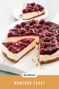 a cheesecake topped with cherries on top of a white paper towel next to a slice cut out