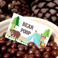 a bowl filled with chocolate covered candies and a sign that says bear poop