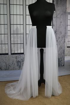 a white tulle skirt on a mannequin with windows in the back ground