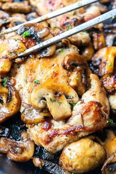 chicken and mushrooms are being cooked with tongs