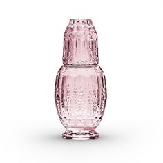 a pink glass vase sitting on top of a white table