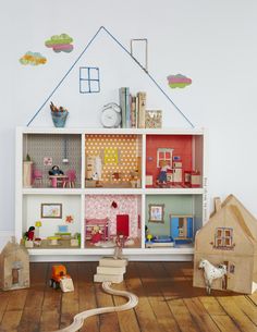 a doll house is on top of a bookcase in the corner of a child's room