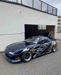 a blue car parked in front of a garage