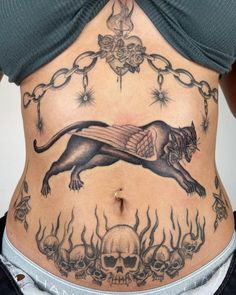 a woman with a tattoo on her stomach has a lion and skulls in the background