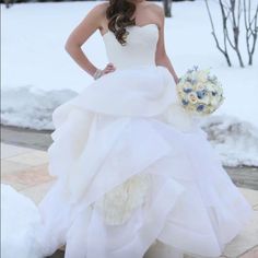 a woman in a white wedding dress posing for the camera