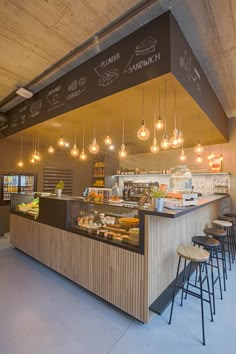 the inside of a restaurant with lots of lights hanging from the ceiling and food on the counter