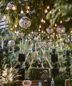 an outdoor party with disco balls hanging from the ceiling and plants in the foreground