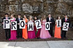 a group of people standing next to each other holding up signs that read prom 2013