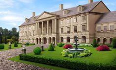 a large building with a fountain in front of it and lots of bushes around the perimeter