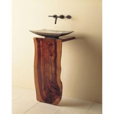 a bathroom sink made out of wood with a metal faucet on the side