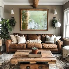 a living room filled with furniture and a painting hanging on the wall above it's coffee table