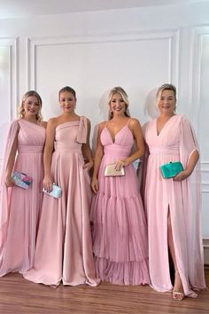 four bridesmaids in pink dresses posing for the camera with one holding her purse