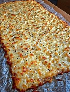 a large cheesy pizza sitting on top of a pan covered in cheese and seasoning