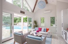 a living room filled with furniture next to a swimming pool