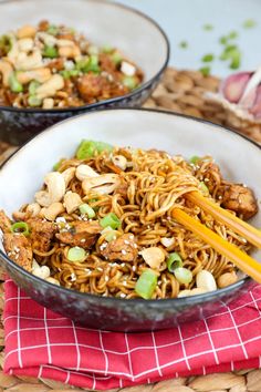 two bowls filled with noodles and vegetables on top of a table