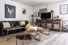 a living room filled with furniture and pictures on the wall