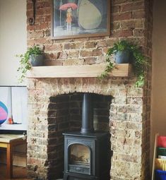 an old brick fireplace with potted plants on top