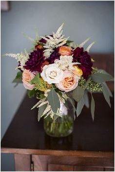 a vase filled with flowers on top of a wooden table