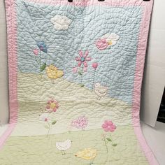 a baby quilt with flowers and birds on it