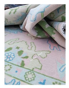 a close up of a pink and blue rug with an animal design on it's side