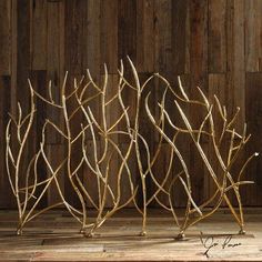 three metal branches sitting on top of a wooden floor