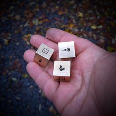 three small wooden blocks in the palm of someone's hand