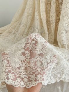 someone is holding the lace on their wedding dress