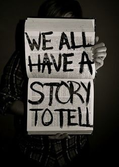 two people holding up signs that say we all have a story to tell